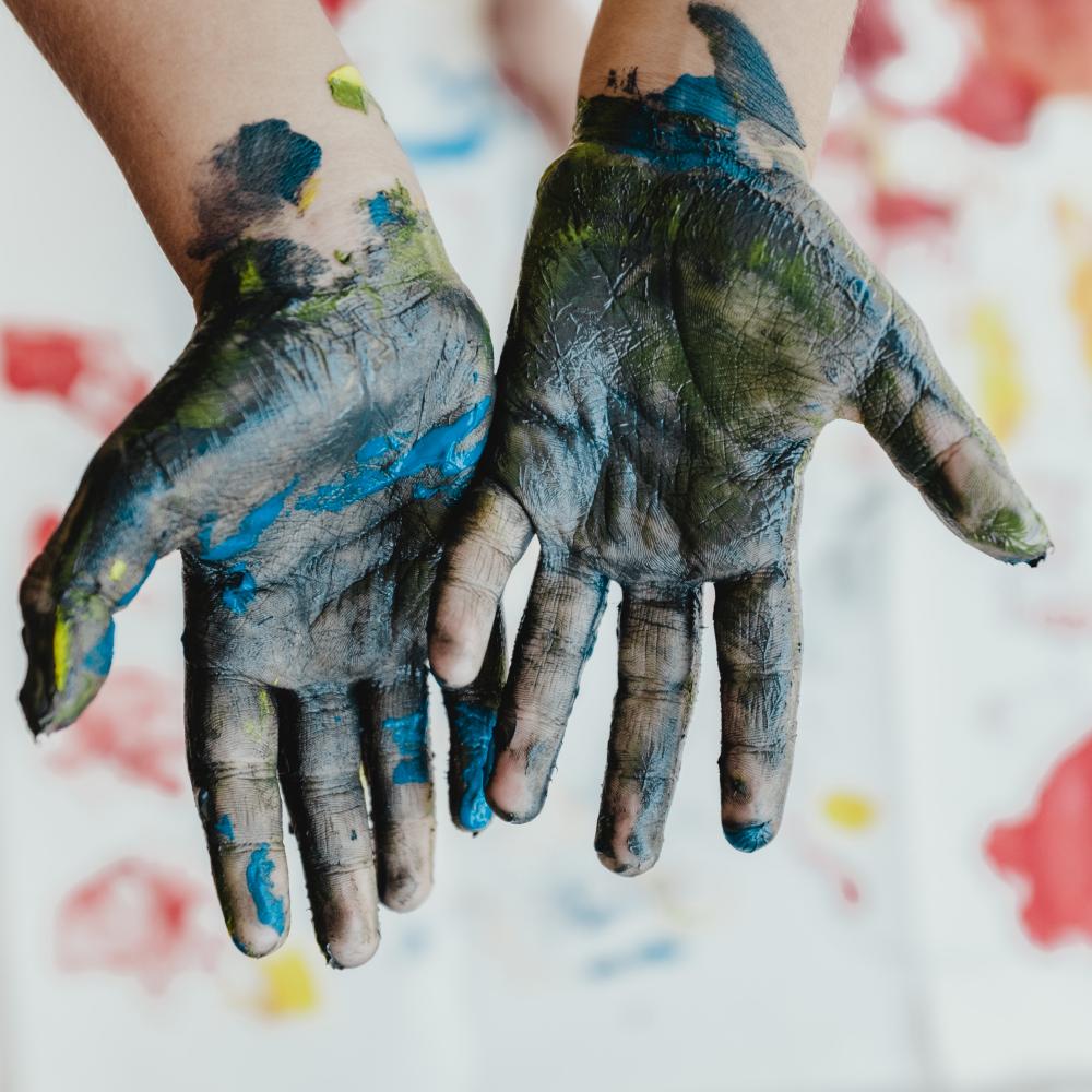 child's hands covered in paint